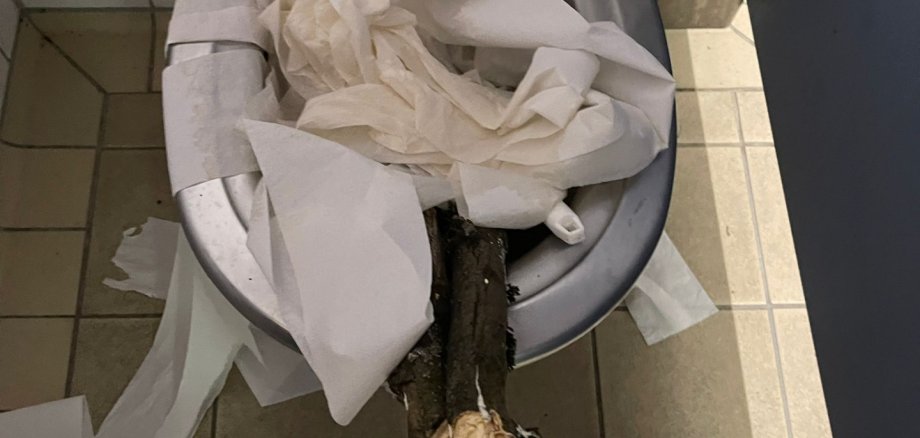 Eine verstopfte Toilette mit Papier und Holz.