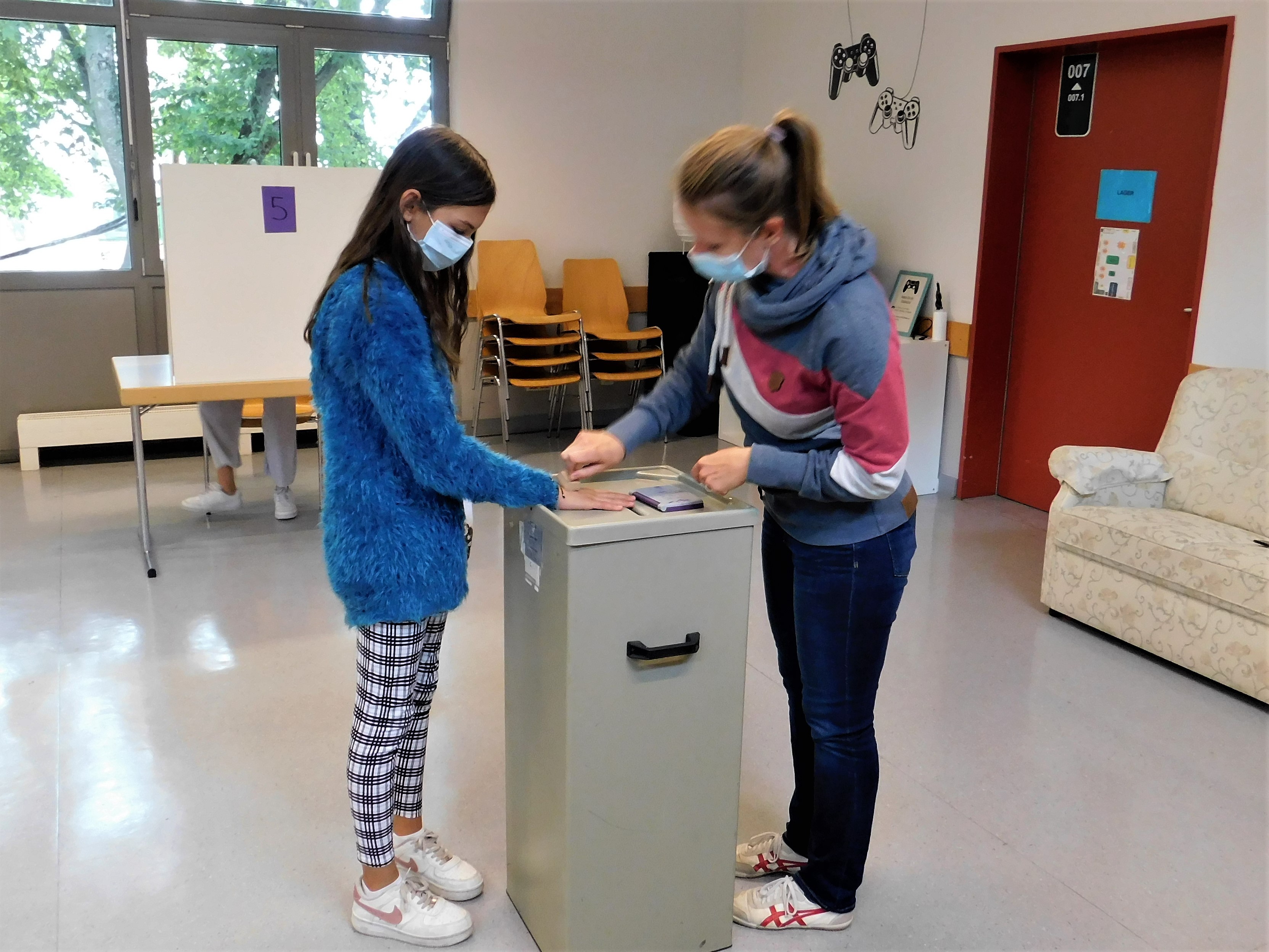 Ein Mädchen bekommt nach der Stimmabgabe einen Stempel auf die Hand.