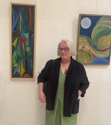 Künstlerin Hirschberg vor ihren Gemälden.