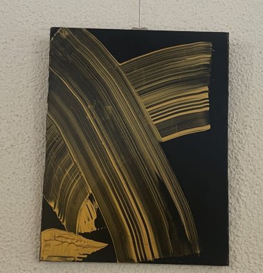 Goldene Farbstreifen auf schwarzem Untergrund.