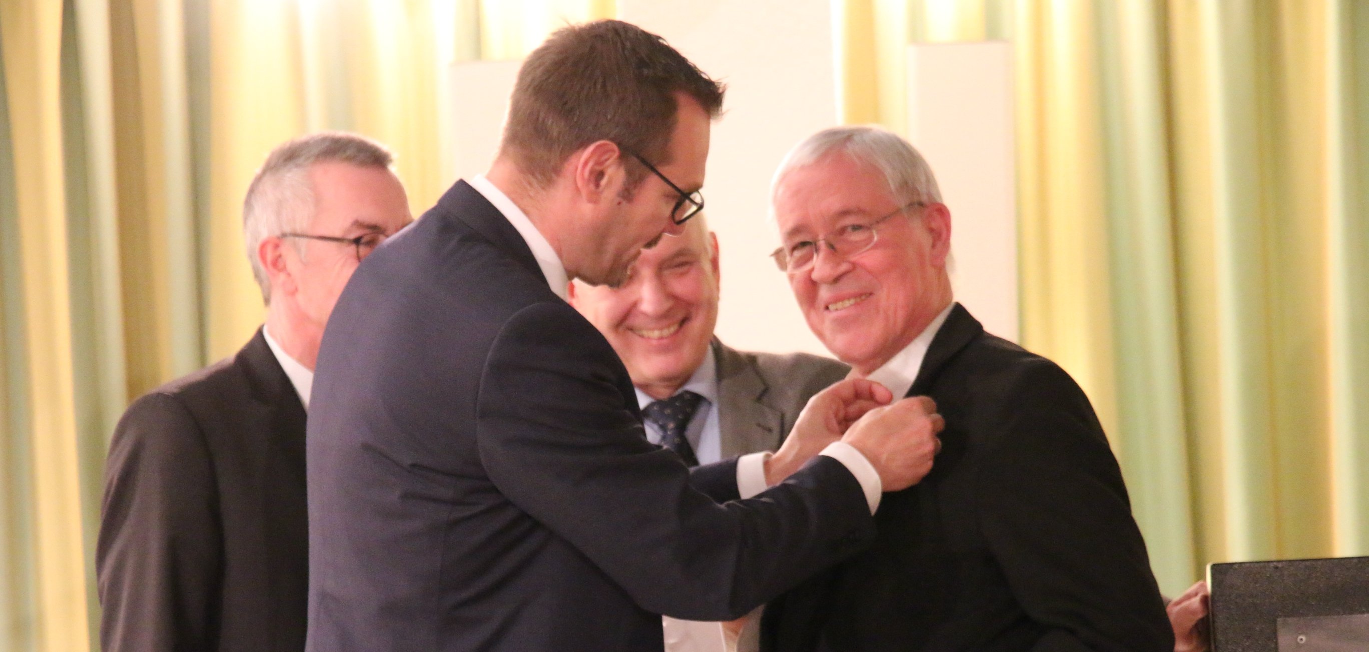 Dietmar Vollmert bekommt von Bürgermeister Seitz die Ehrenplakette angesteckt.