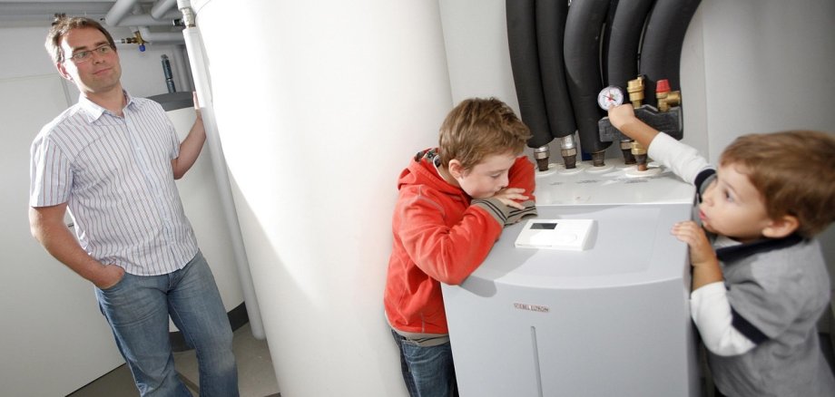 Familie neben einer Wärmepumpe.