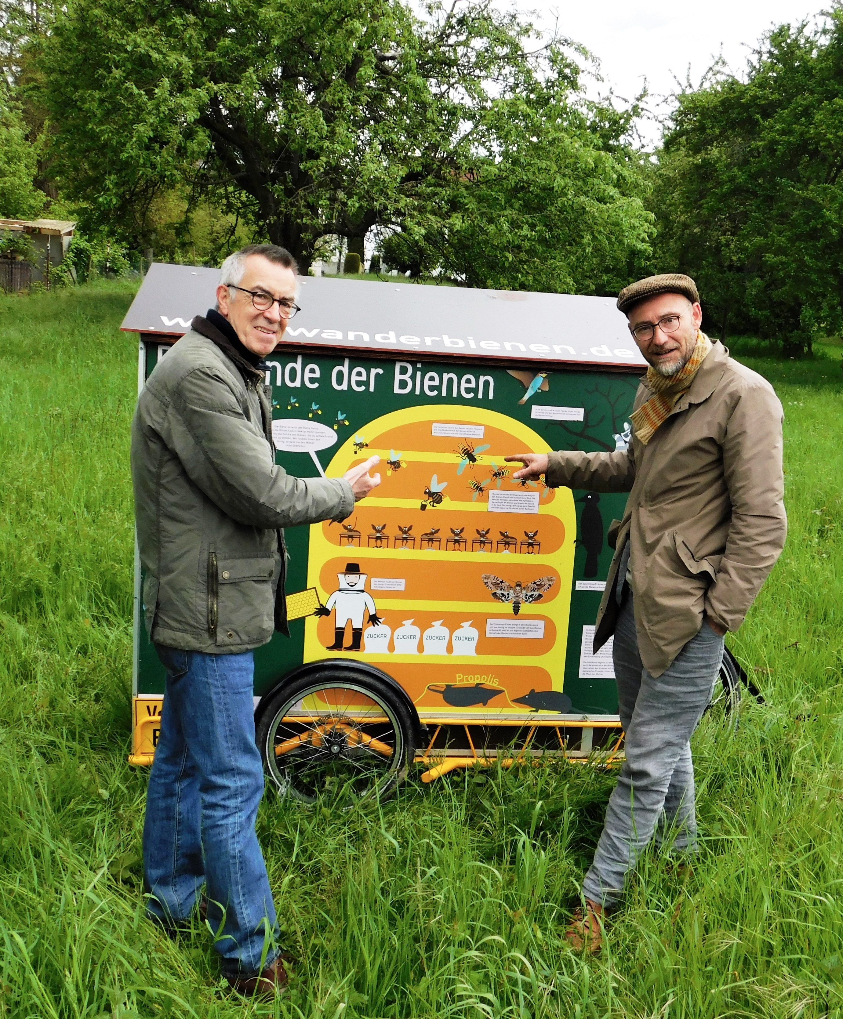 Imker Wolf und der Erstze Beigeordnete Jirasek vor dem bunten Bienenwagen.