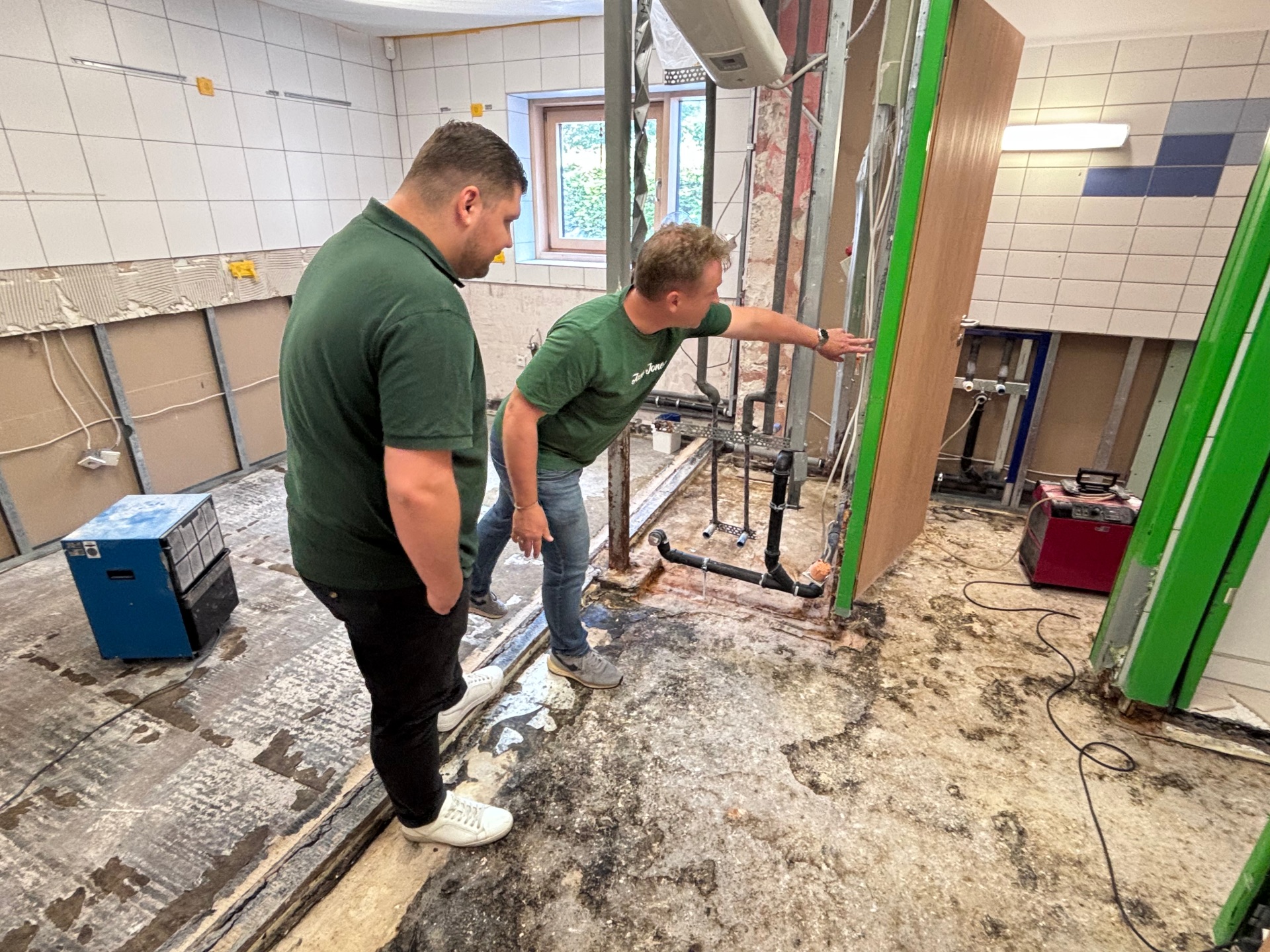 Der Erste Beigeordnete mit Handwerker in entkernter Küche.