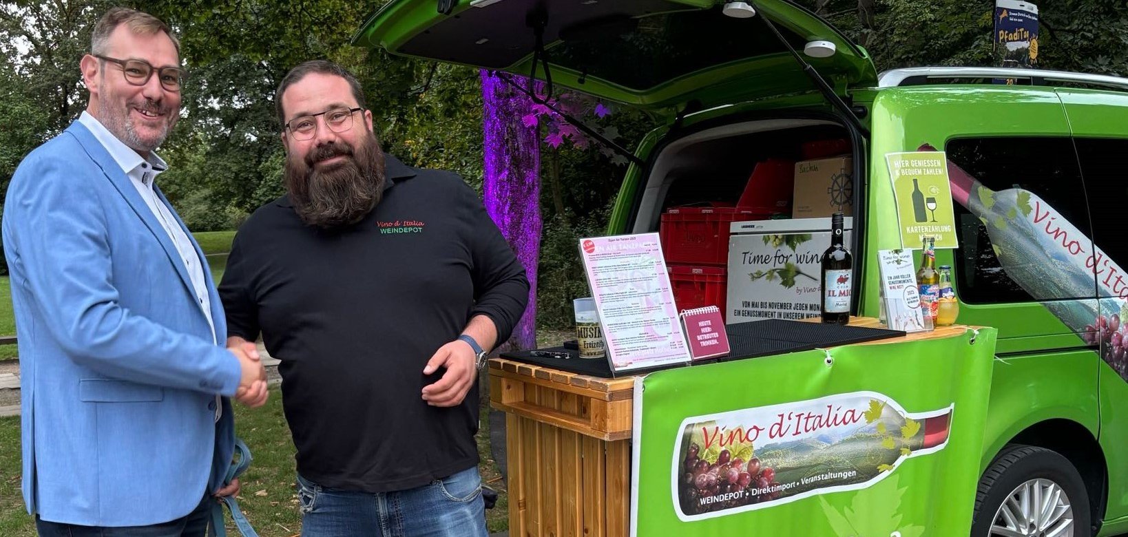 Bürgermeister mit Lucas Schleß vor dem Weinstand.