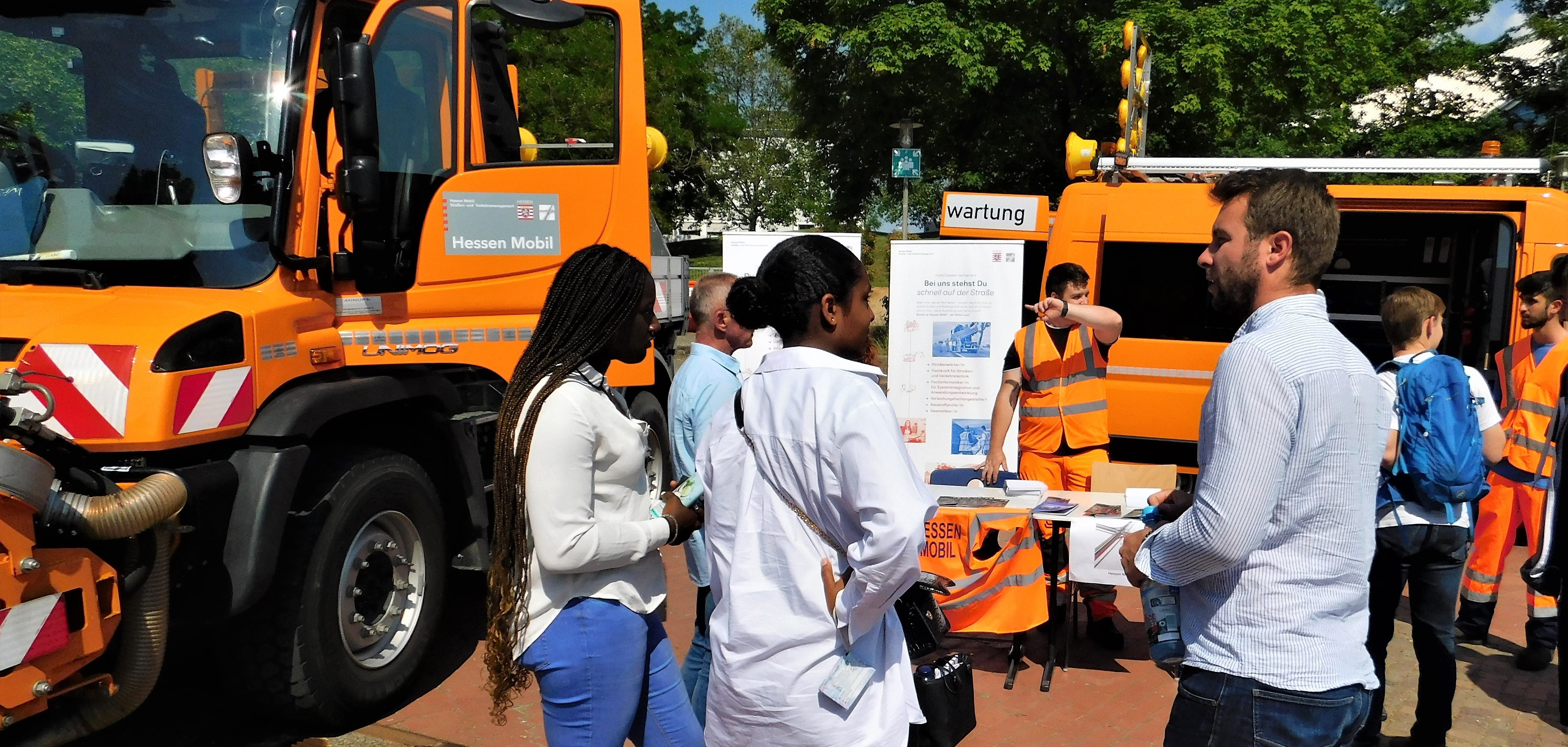 Mädchen vor Unimogs.