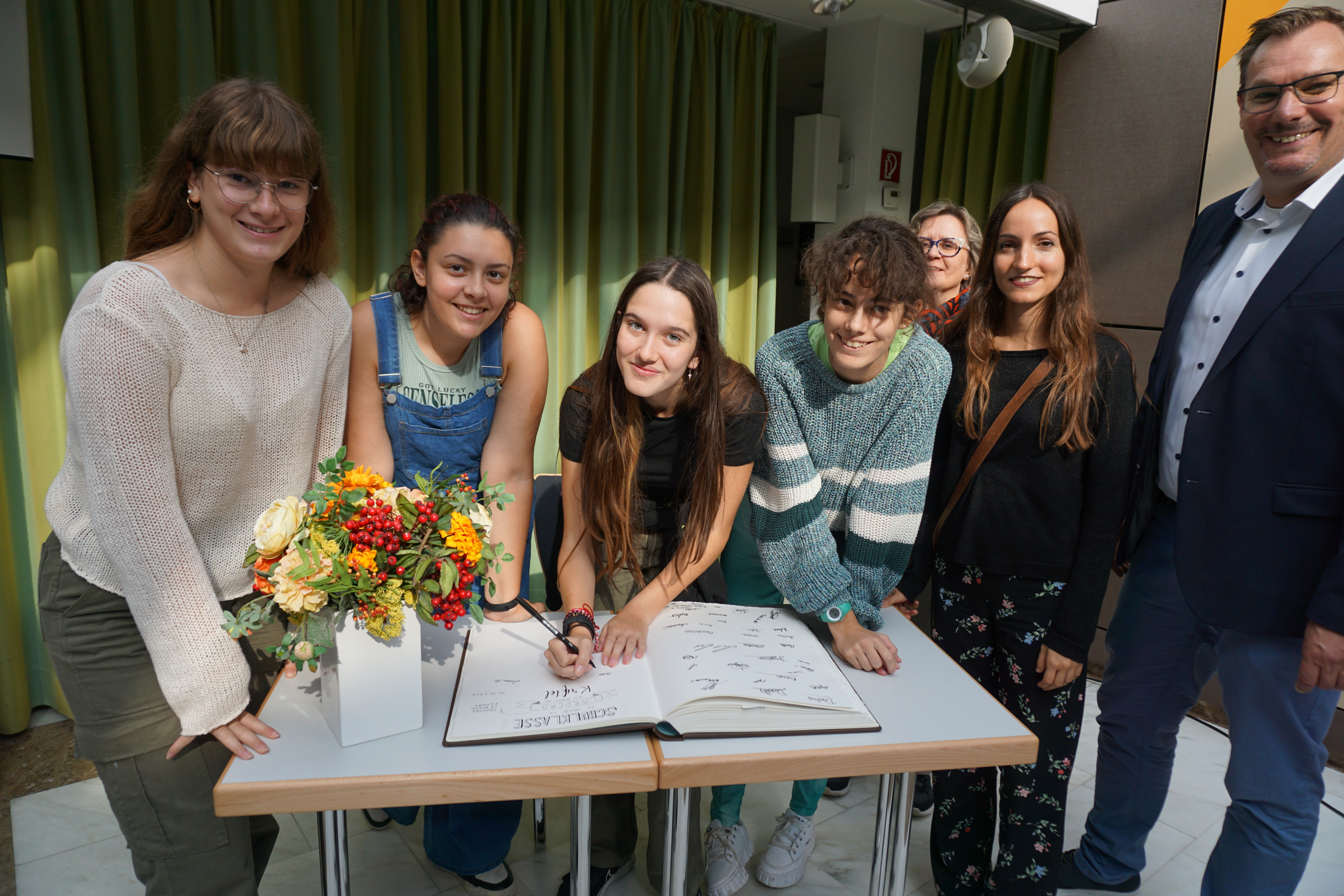 Spanische Schülerinnen tragen sich ins Goldene Buch ein.