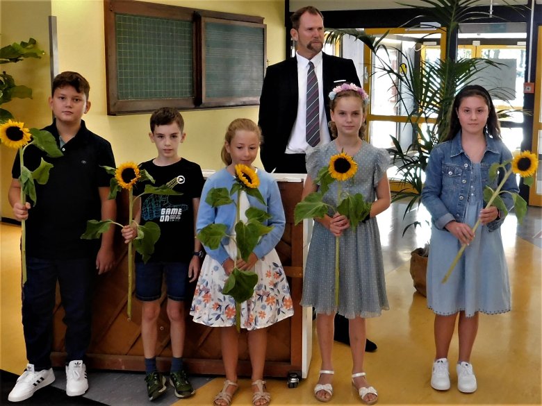 Dr. Richter hinter Schülern mit Sonnenblumen.