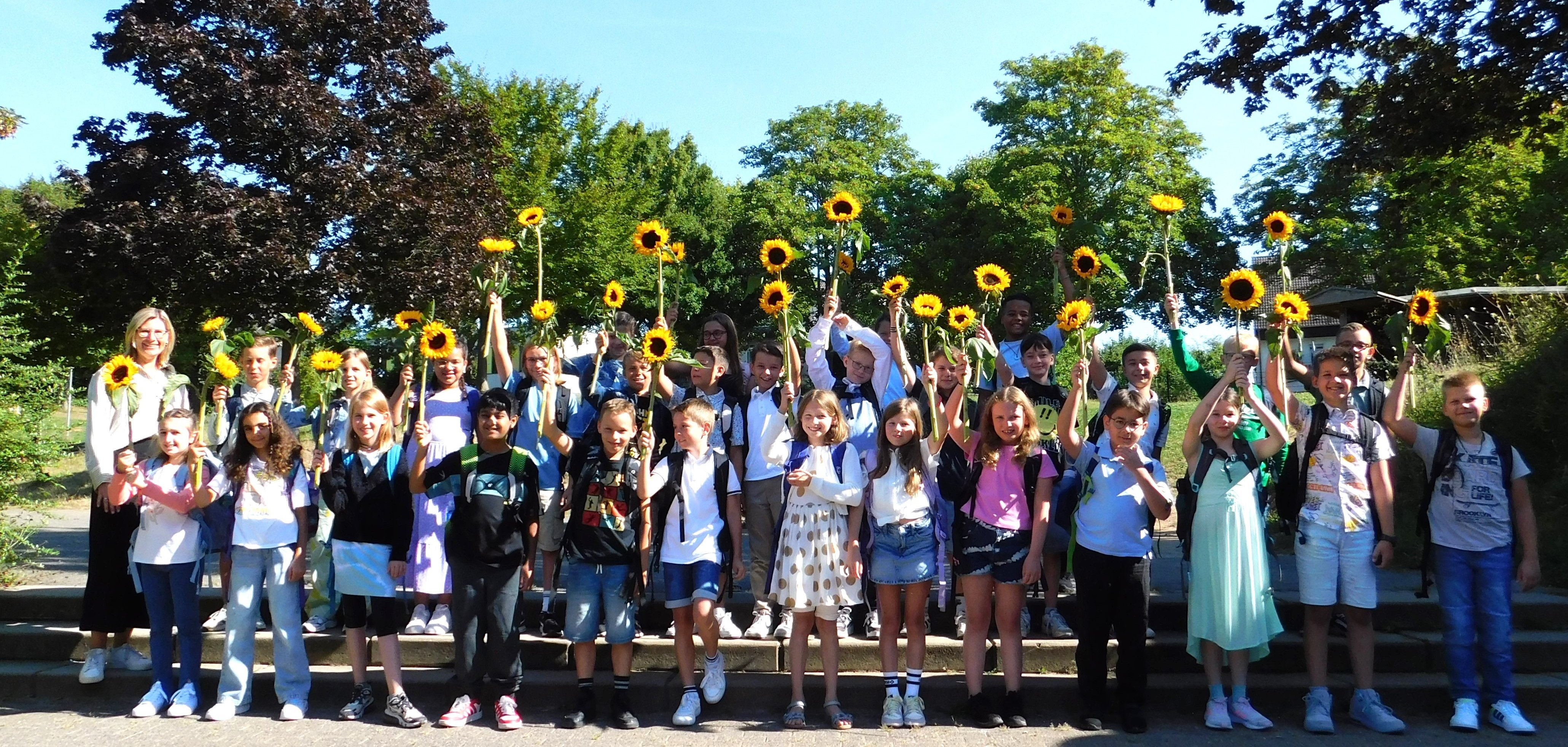 Die neuen Schüler/innen mit ihren Sonnenblumen.
