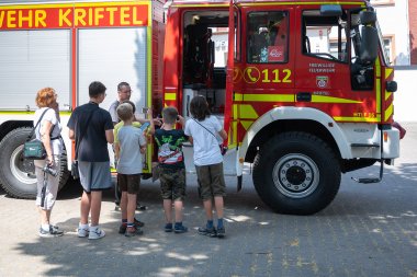 Kinder vor einem Feuerwehrauto.