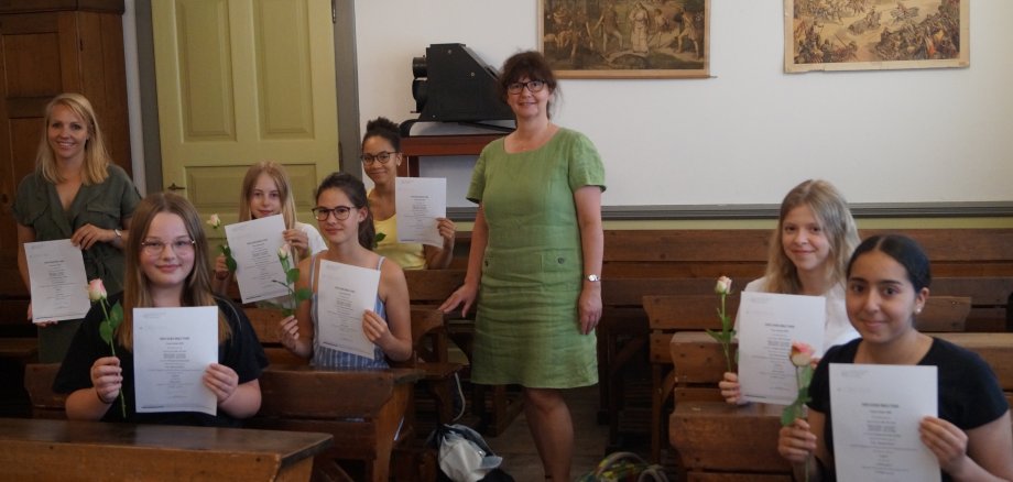 Die Schüler und Lehrer mit Urkunden im Schulmuseum.