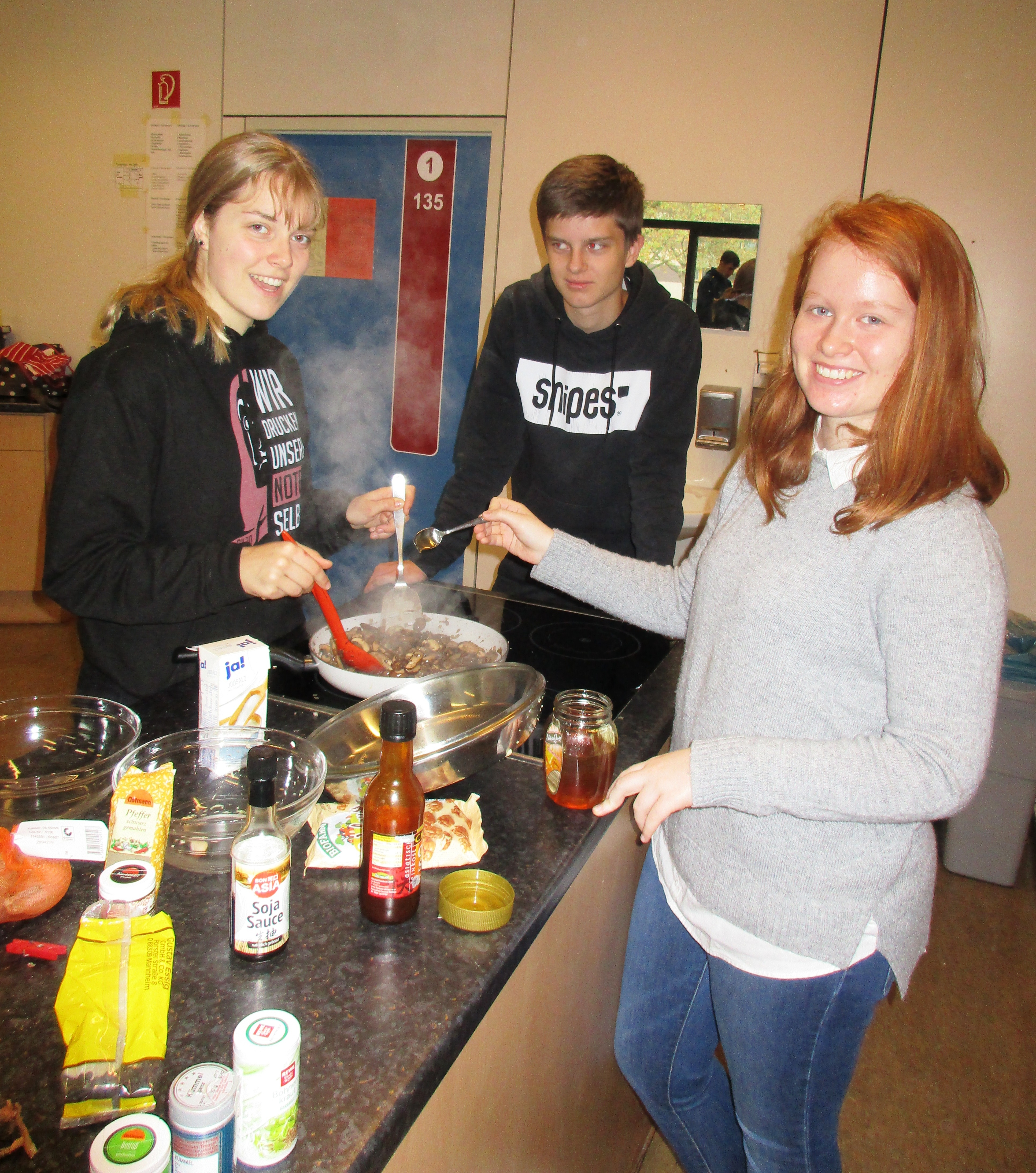 Schüler der Weingartenschule rühren in der Schulküche in einer Pfanne.