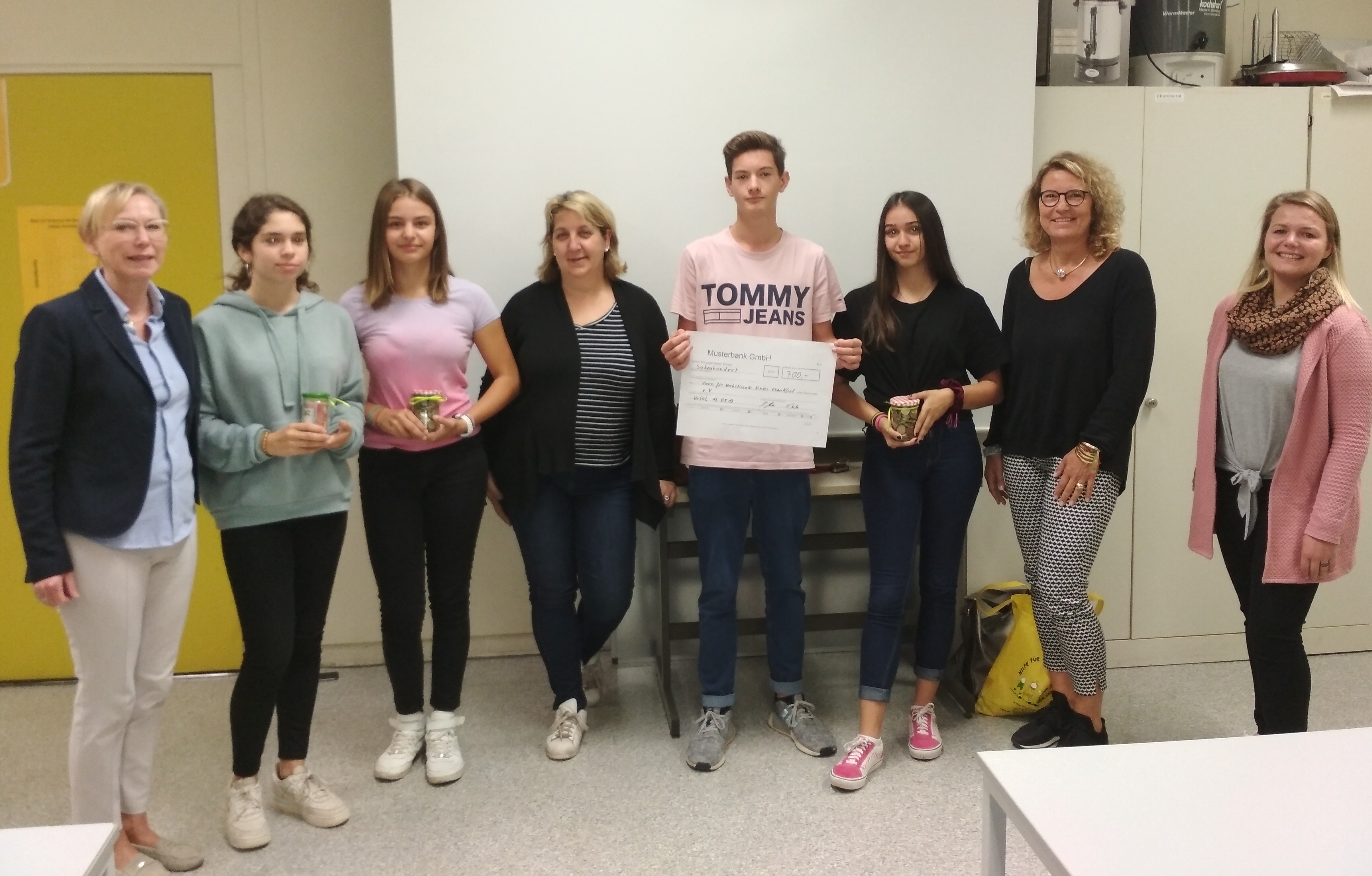 Die Schüler und Lehrer übergeben den Spendenscheck.