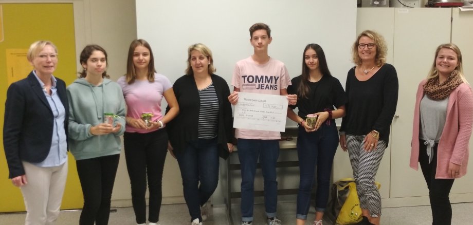 Die Schüler und Lehrer übergeben den Spendenscheck.