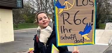 Lehrerin mit Plakat.