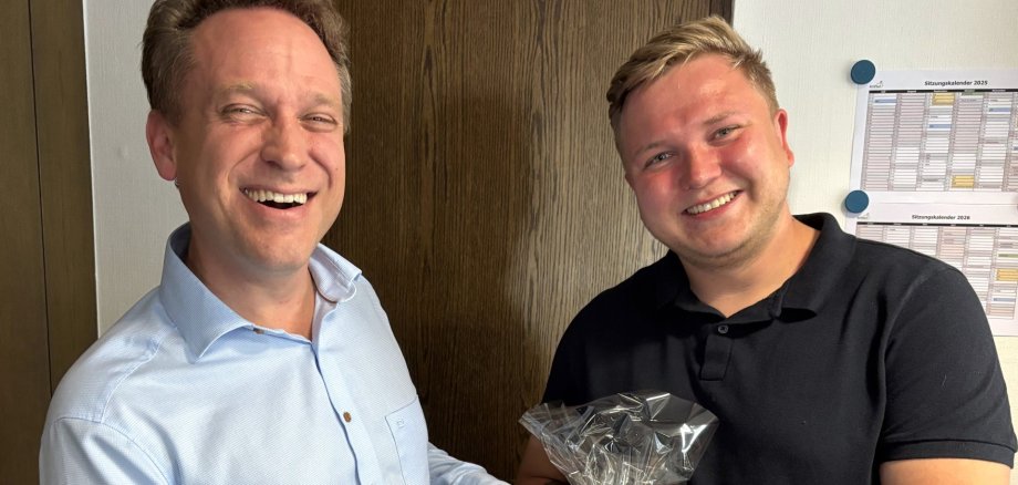 Mohr und Gebauer mit einem Glaswappen der Gemeinde.