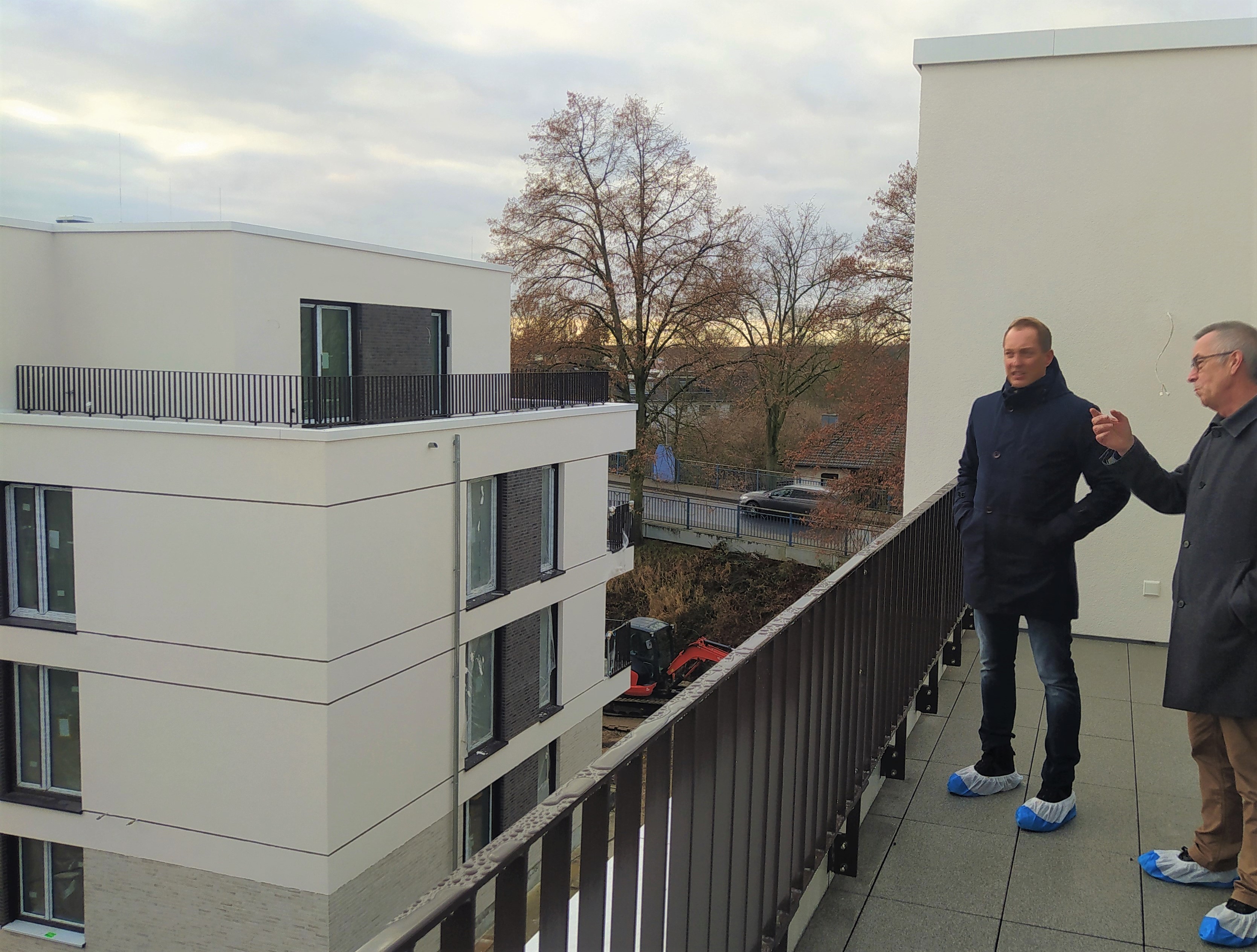 Der Erste Beigeordnete Franz Jirasek auf einem Balkon der neuen Häuser in der Bahnhofstraße.