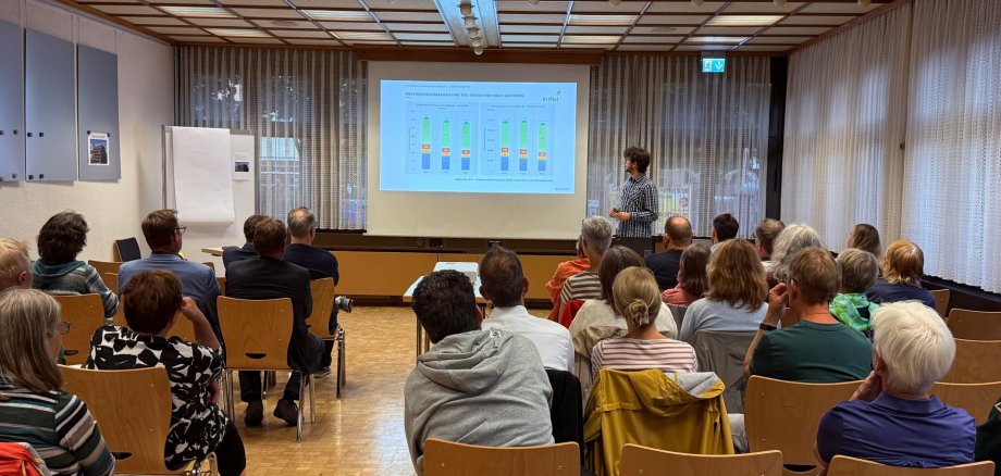Der Referent der energielenker vor vollbesetzten Stühlen.