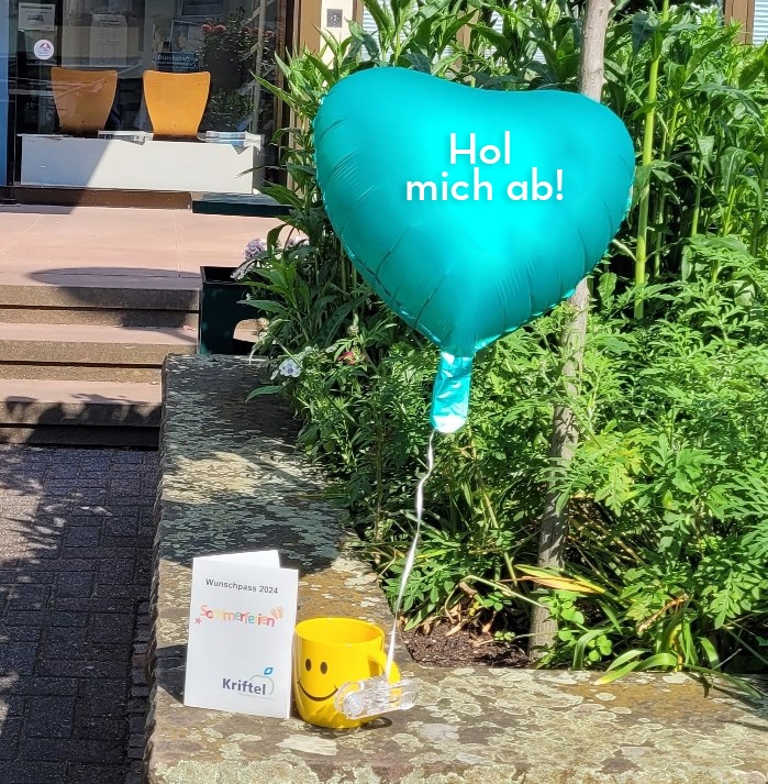 Der Wunschpass, eine Tasse und ein Ballon vor dem Rathaus.