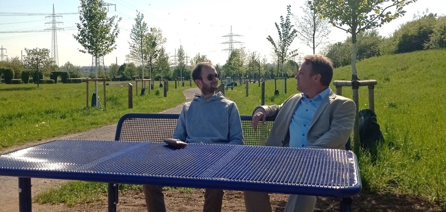 Mohr und Horn sitzen am Tisch im Ziegeleipark.