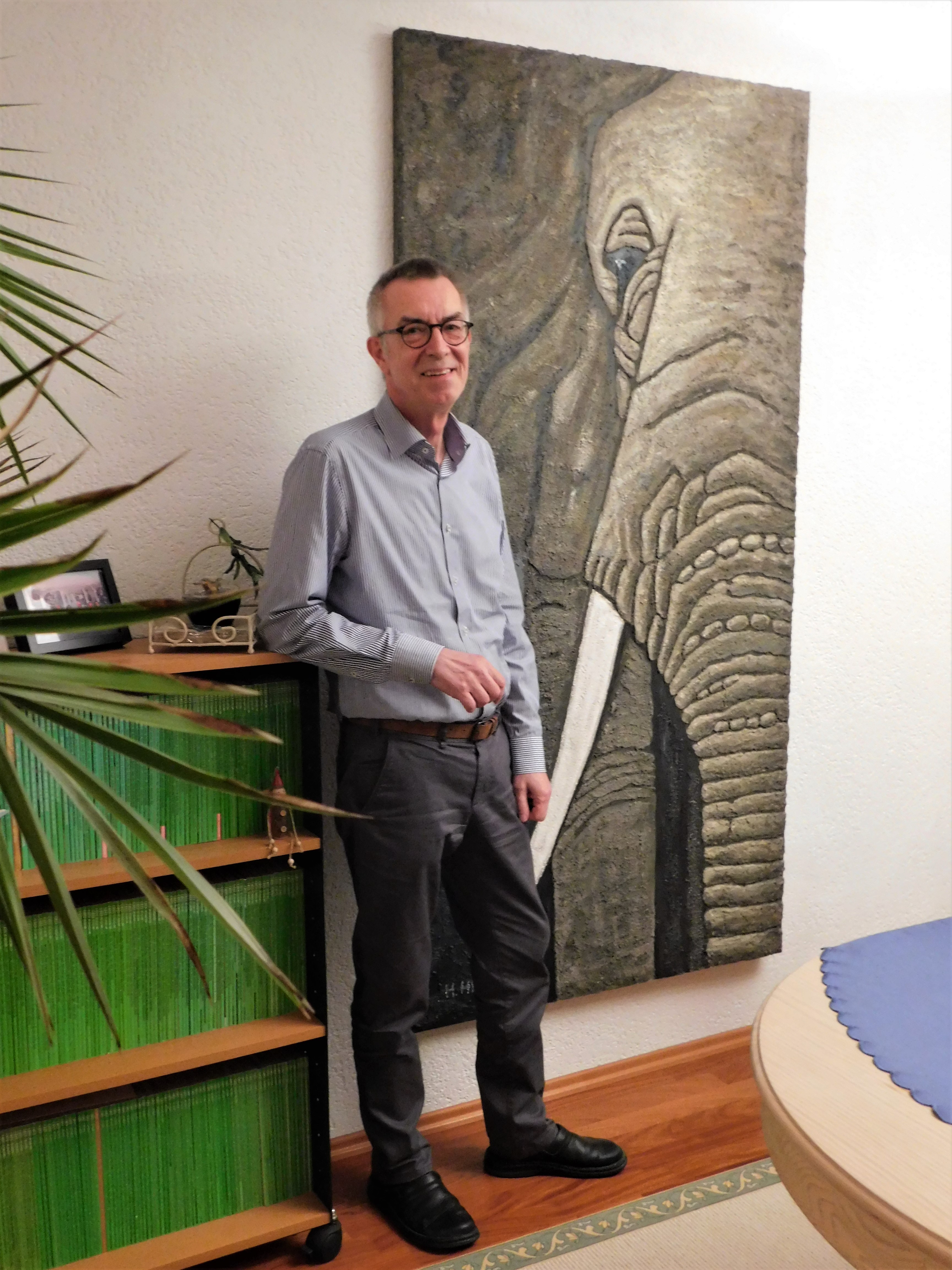 Jirasek in seinem Wohnzimmer vor einem Elefantenbild.