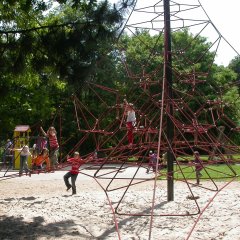 spielende Kinder auf der Kletterpyramide auf dem Spielplatz im Freizeitpark.