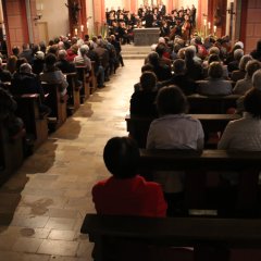 Blick auf die Rücken der Menschen auf den Kirchenbänken während eines Gottesdienstes