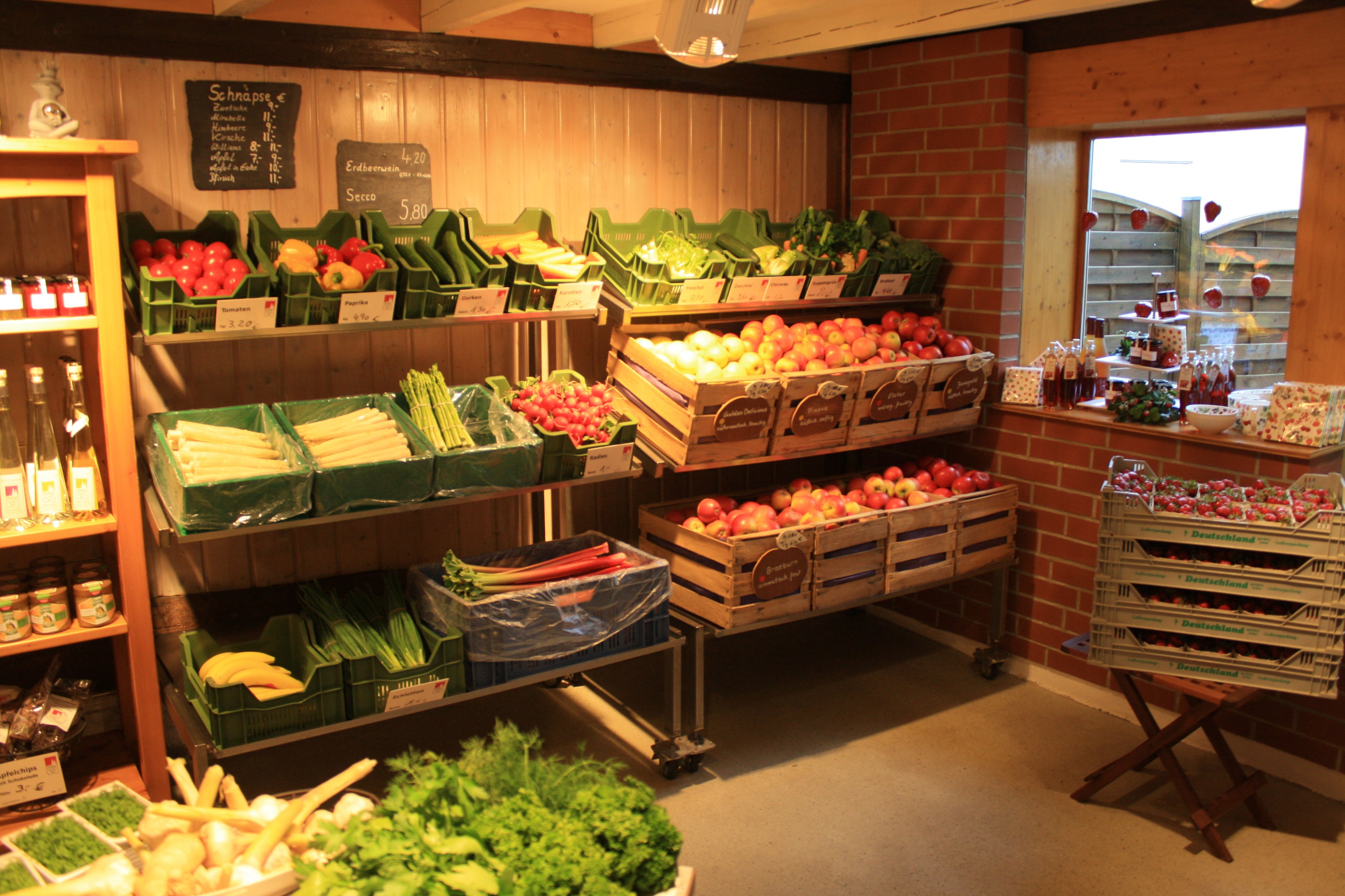 Blick in einen Hofladen mit Regalen voller Gemüse