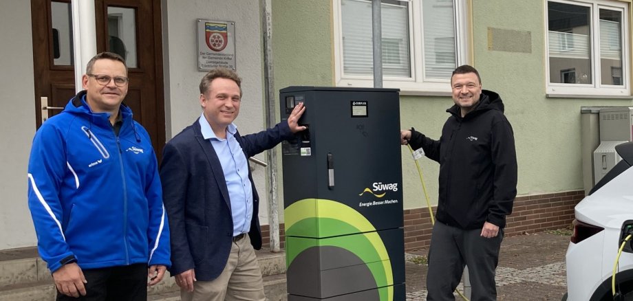Die Beteiligten stehen an der Ladesäule.