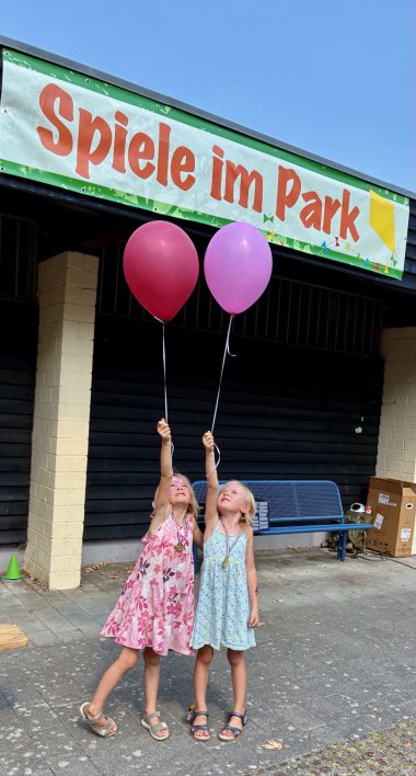 Zwillinge mit Luftballons.