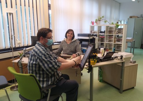 Ein Bürger sitzt vor dem Schreibtisch einer Bürgerservice-Mitarbeiterin.